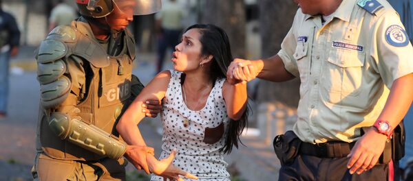 Снаге безбедности Венецуеле ухапсиле жену током нереда у Каракасу. - Sputnik Србија
