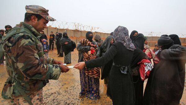 Jordanski vojnik proverava identifikacione kartice sirijskih izbeglica u kampu Rukban - Sputnik Srbija