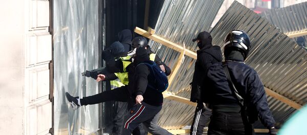 Демонстранти демолирају излог луксузне продавнице на протестима Жутих прслука у Паризу - Sputnik Србија