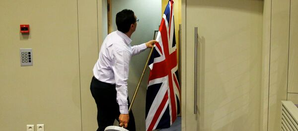 Званичник носи заставу Велике Британије у Бриселу Званичник носи заставу Велике Британије у Бриселу - Sputnik Србија