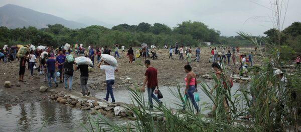 Људи прелазе реку Тачира на колумбијско-венецуеланској граници Људи прелазе реку Тачира на колумбијско-венецуеланској граници - Sputnik Србија