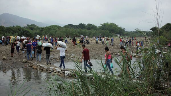 Ljudi prelaze reku Tačira na kolumbijsko-venecuelanskoj granici - Sputnik Srbija