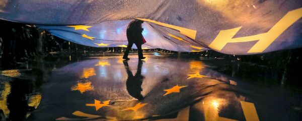 Čovek ispod zastave EU Čovek ispod zastave EU - Sputnik Srbija