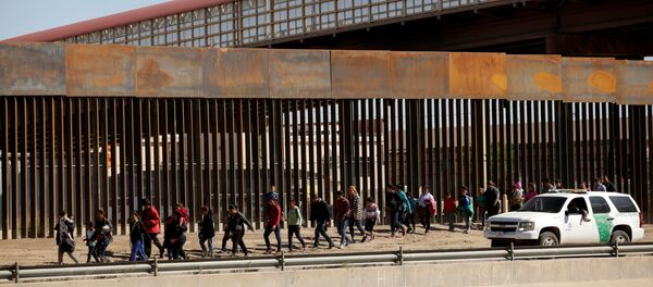Амерички граничници спроводе мигранте на граници са Мексиком који су покушали нелегално да пређу границу са Сједињеним Америчким Државама - Sputnik Србија