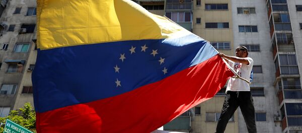 Pristalica opozicionog lidera Huana Gvaida nosi zastavu na mitingu protiv aktuelnog predsednika Venecuele Nikolasa Madura Pristalica opozicionog lidera Huana Gvaida nosi zastavu na mitingu protiv aktuelnog predsednika Venecuele Nikolasa Madura - Sputnik Srbija