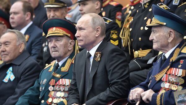 Ruski predsednik Vladimir Putin u društvu veterana Velikog otadžbinskog rata posmatra paradu povodom Dana pobede - Sputnik Srbija