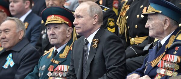 Руски председник Владимир Путин у друштву ветерана Великог отаџбинског рата посматра параду поводом Дана победе - Sputnik Србија