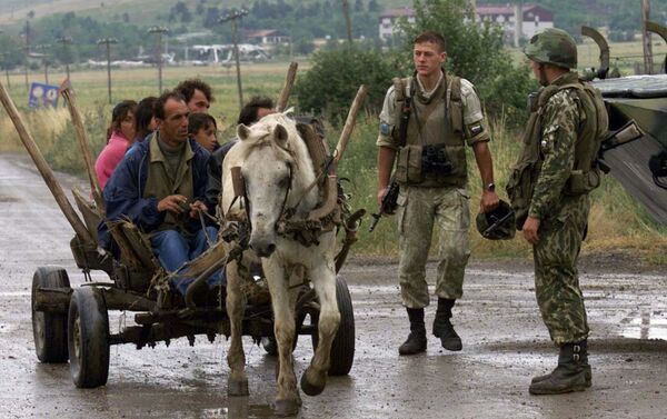 Албанци пролазе поред руских војника који су били смештени на аеродрому Слатина. - Sputnik Србија