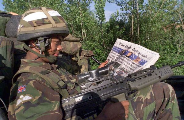 Британски војник чита новине на контролном пункту у Приштини. - Sputnik Србија