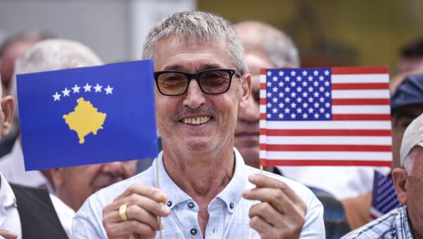 Kosovski Albanac u rukama drži zastave SAD i takozvanog Kosova - Sputnik Srbija