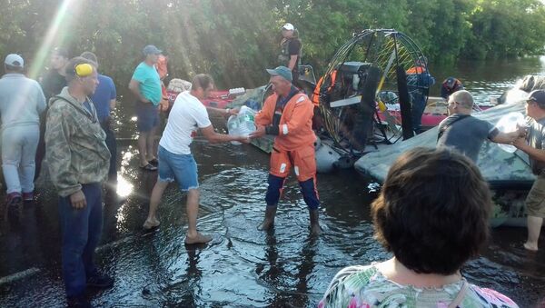 Припадници Министарства за ванредне ситуације доносе воду за пиће становницима поплављених насеља у Иркутској области - Sputnik Србија