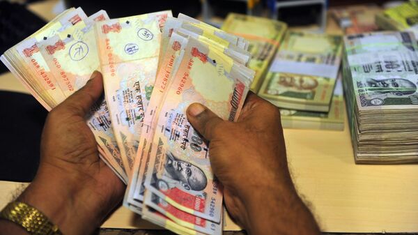 Службеник проверава индијске рупије у банци у Мумбају - Sputnik Србија