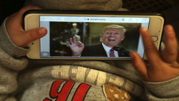 Donald Tramp, predsednik SAD na ekranu mobilnog telefona - Sputnik Srbija