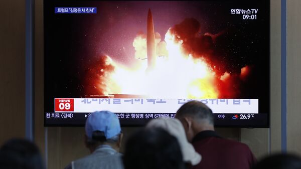 Људи гледају извештај о лансирању ракета у Северној Кореји на железничкој станици у Сеулу - Sputnik Србија