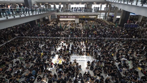 Demonstranti sede u sali aerodroma na protestu u Hongkongu - Sputnik Srbija