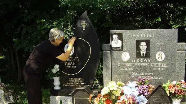 Goraždevac: Majka Ivana Jovića, koji je ubijen na reci Bistrici 13. avgusta 2003. godine, na njegovom grobu  - Sputnik Srbija
