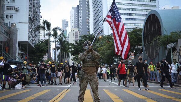 Demonstrant na protestu u Hongkongu nosi američku zastavu  - Sputnik Srbija
