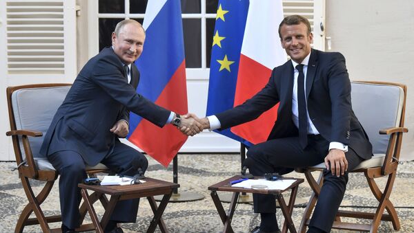 Predsednik Rusije Vladimir Putin rukuje se sa predsednikom Francuske Emanuelom Makronom na sastanku u tvrđavi Breganson - Sputnik Srbija