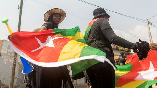 Žena drži zastavu Togoa u glavnom gradu ove zemlje Lomeu - Sputnik Srbija