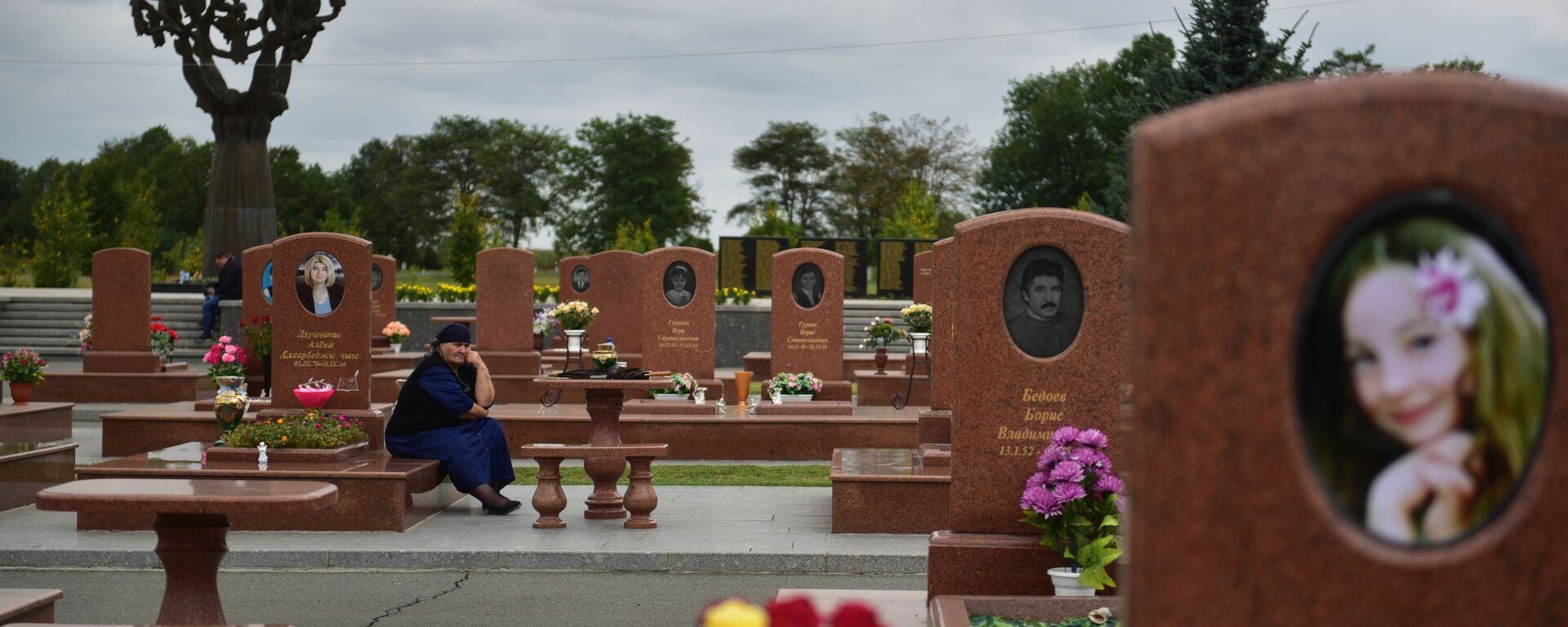 Жена плаче на гробљу Град анђела у Беслану где су сахрањени погинули у терористичком нападу 1. септембра 2004. године. - Sputnik Србија, 1920, 03.09.2020