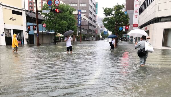 Људи се пробијају кроз поплављене улице јапанског града Сага - Sputnik Србија