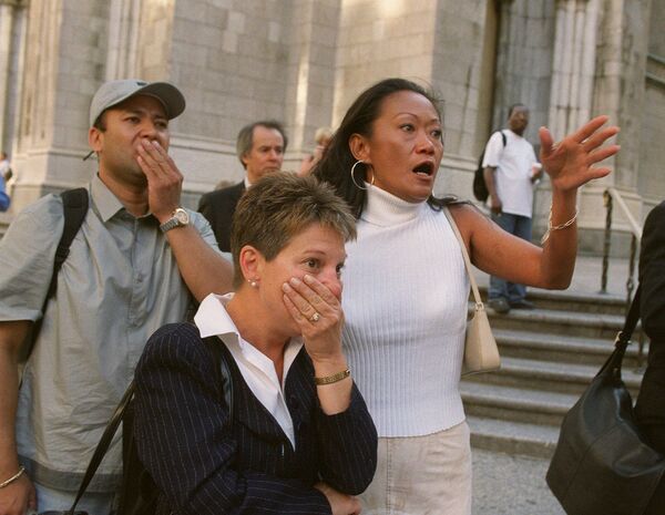 Људи на улици гледају шта се дешава у кулама Светског трговинског центра после терористичког напада 11. септембра 2001. године. - Sputnik Србија