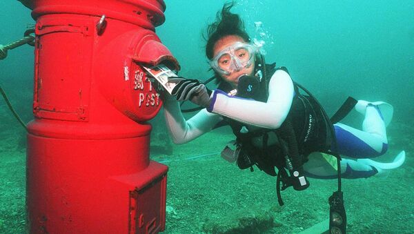 Žena ronilac stavlja plastificirano pismo u poštansko sanduče postavljeno na dubini od 10 metara na dnu mora kraj obale Susamija, prefektura VakaJama, 7. jula 1999. godine. - Sputnik Srbija