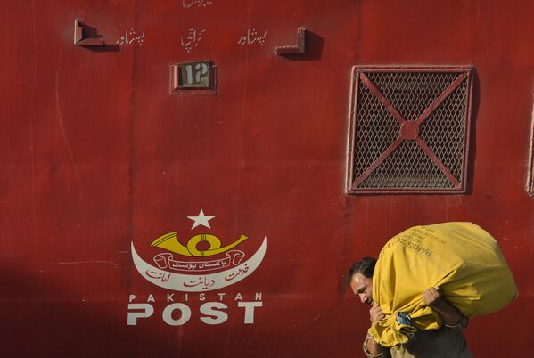 Пакистански поштар доставља пошту на железничкој станици у Лахору 8. октобра 2017. године, уочи Светског дана поште. - Sputnik Србија