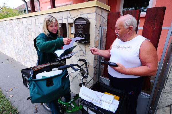Радница Мађарске поштарска компаније Бернадет Каса доставља писмо човеку округа у Будимпешти, 18. октобра 2013. - Sputnik Србија