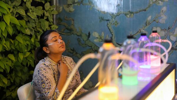 Žena udiše kiseonik pomešan sa aromaterapijom u baru sa kiseonikom u Nju Delhiju - Sputnik Srbija