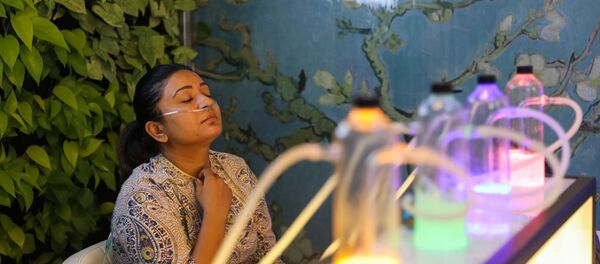 Žena udiše kiseonik pomešan sa aromaterapijom u baru sa kiseonikom u Nju Delhiju Žena udiše kiseonik pomešan sa aromaterapijom u baru sa kiseonikom u Nju Delhiju - Sputnik Srbija