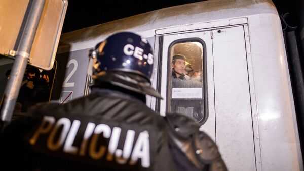 Хрватски полицајац испред воза са мигрантима - Sputnik Србија