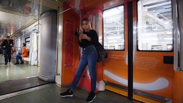Девојка гледа у телефон у возу московског метроа - Sputnik Србија