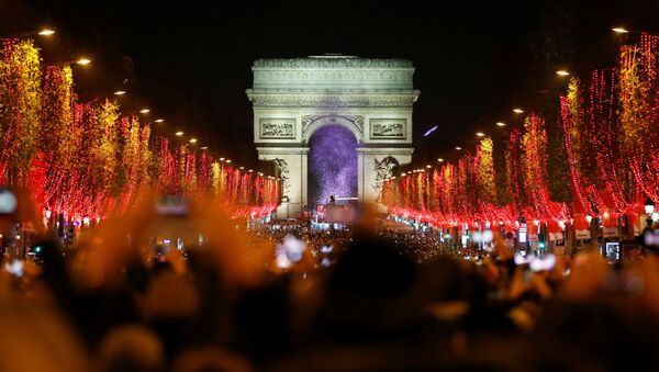 Становници и посетиоци Париза посматрају свечано паљење новогодишње расвете на Јелисејским пољима - Sputnik Србија
