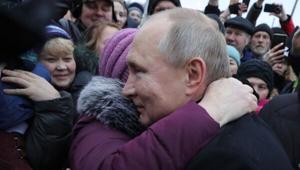 Predsednik Rusije Vladimir Putin grli uplakanu ženu tokom razgovora sa stanovnicima Sankt Peterburga - Sputnik Srbija