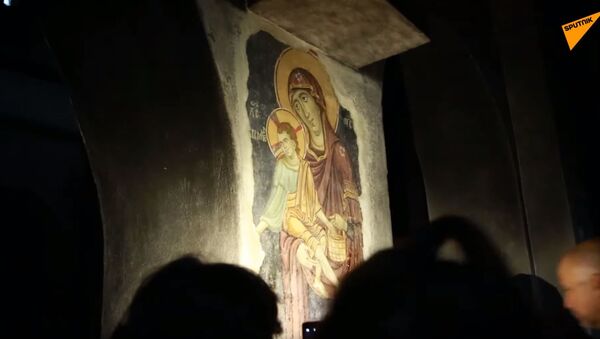 Lice Bogorodice i drugih svetitelja tokom večernje molitve vernici i turisti otkrivaju svetlima moblinih telefona. - Sputnik Srbija