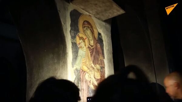 Lice Bogorodice i drugih svetitelja tokom večernje molitve vernici i turisti otkrivaju svetlima moblinih telefona. - Sputnik Srbija