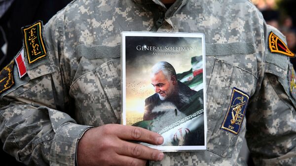 Demonstrant nosi fotografiju generala Kasema Sulejmanija na protestu protiv njegovog ubistva u Teheranu - Sputnik Srbija