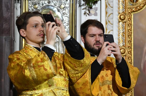 Pravoslavni sveštenici slikaju tokom božićne liturgije u Hramu Hrista Spasitelja u Moskvi - Sputnik Srbija