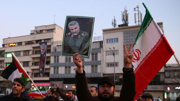 Čovek drži fotografiju ubijenog iranskog generala Kasema Sulejmanija tokom slavlja zbog napada Irana na američke vojne baze u Iranu - Sputnik Srbija
