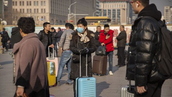 Путници снимљени на железничкој станици у Пекингу са заштитним маскама - Sputnik Србија