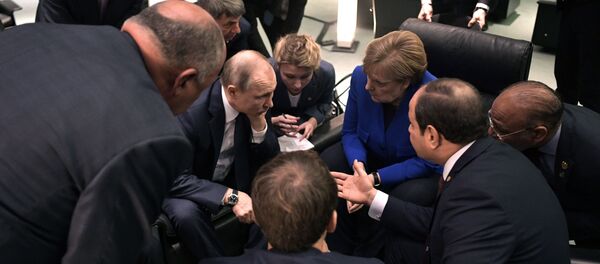 Председник Русије Владимир Путин и немачка канцеларка Ангела Меркел окружени званичницима на маргинама конференције о Либији у Берлину - Sputnik Србија