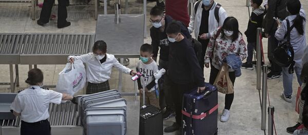 Путници носе маске на железничкој станици у Хонгконгу - Sputnik Србија