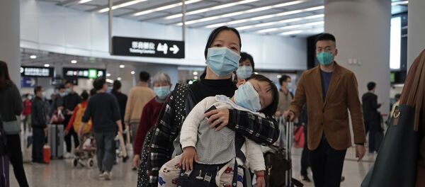Putnici nose zaštitne maske za lice na ulazu železničke stanice u Hongkongu - Sputnik Srbija