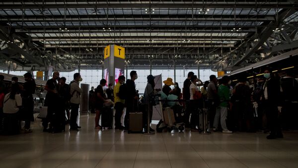 Turisti sa maskama čekaju u redu na aerodromu - Sputnik Srbija