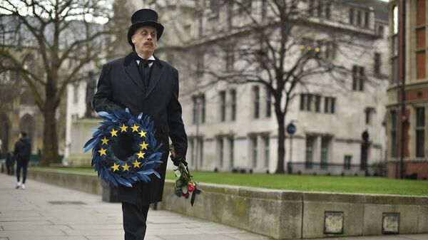 Čovek obučen kao grobar nosi venac za zastavom Evropske unije u Londonu uoči bregzita. - Sputnik Srbija