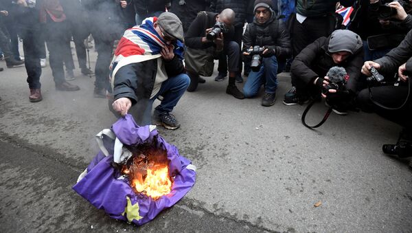 Човек пали заставу Европске уније на Дан Брегзита у Лондону - Sputnik Србија