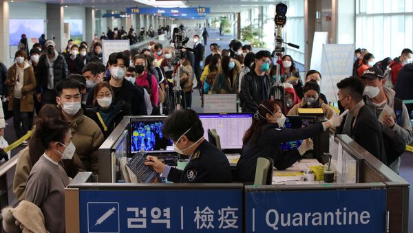 Путници из Кине са маскама на лицу пролазе контролу на аеродрому - Sputnik Србија