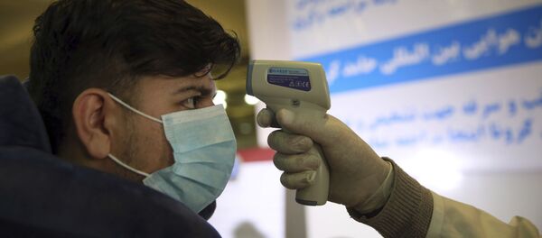 Medicinski radnik proverava telesnu temperaturu putniku na međunarodnom aerodromu u Kabulu u Avganistanu - Sputnik Srbija