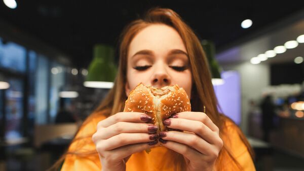 Devojka jede burger - Sputnik Srbija